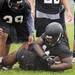 Ypsilanti Community High School Devon Campbell recovers a dropped ball during practice in the rain at the school on Monday, August 12, 2013. Melanie Maxwell | AnnArbor.com